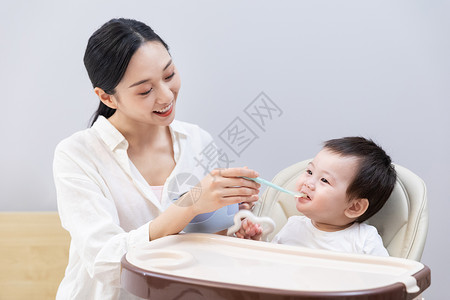 亚洲婴儿妈妈喂婴儿吃东西背景
