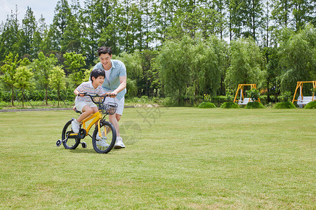 骑车春游的男孩爸爸配小男孩骑单车背景