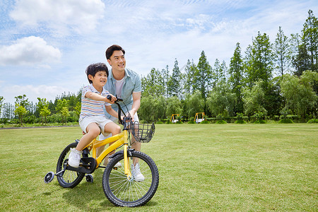 带你旅行爸爸带着小男孩骑单车背景