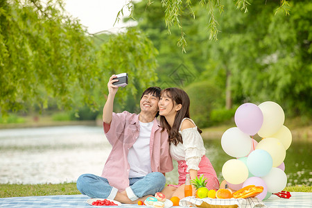 青年情侣野餐拍照自拍图片