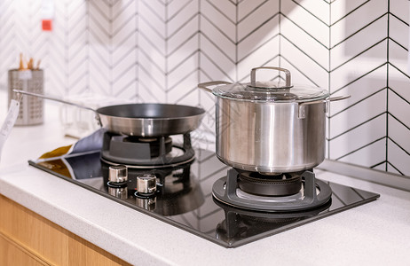 不锈钢铸造厨房用品厨具不锈钢锅与燃气灶台背景