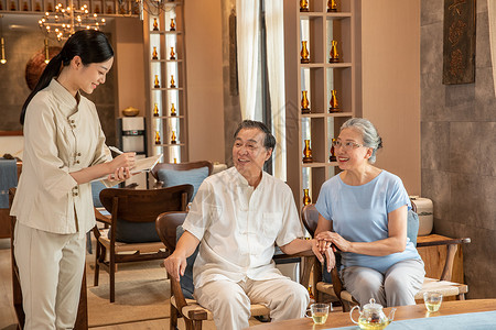 中医养生馆员工服务老年夫妻高清图片
