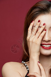 豆沙红美甲时尚美女用手半遮脸背景