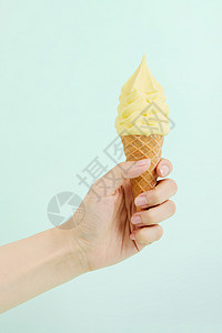 手拿芒果奶油冰淇淋甜筒图片