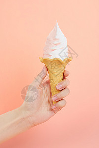 手持草莓奶油双色冰淇淋甜筒高清图片