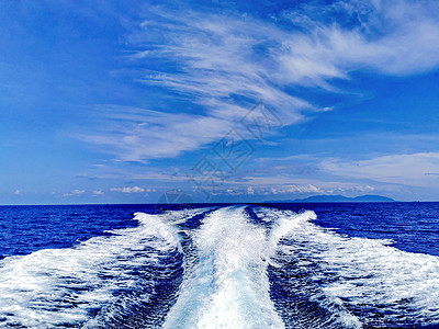 董快艇在海面上掀起的浪花背景