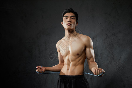 使用拉力绳健身训练的运动男性高清图片
