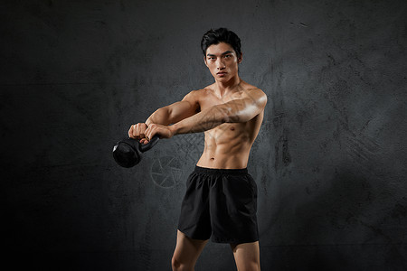 使用壶铃健身的运动男性背景图片