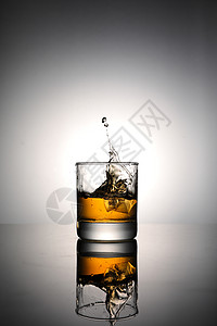 冰块落入一杯威士忌中背景图片