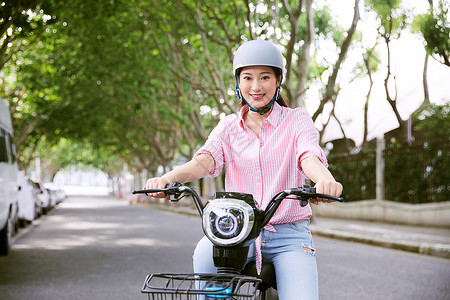 一盔一带安全知识宣传栏青年女性户外骑电动车背景