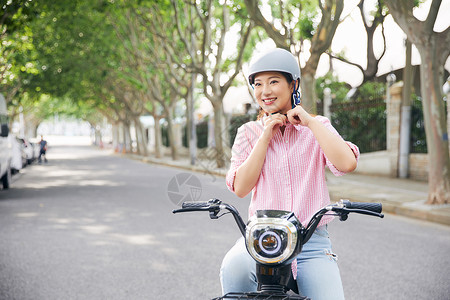 美女户外骑电动车戴头盔图片