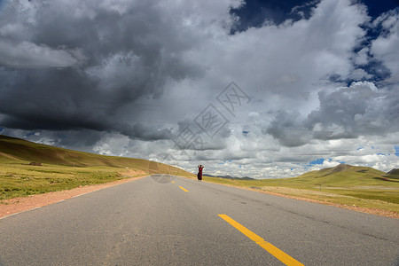 草原上的马路西藏公路上朝拜者背景