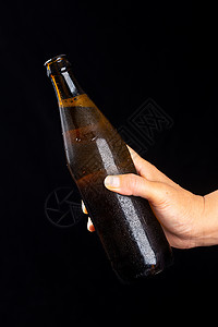 黑色背景拍摄手里拿着黑色啤酒瓶图片