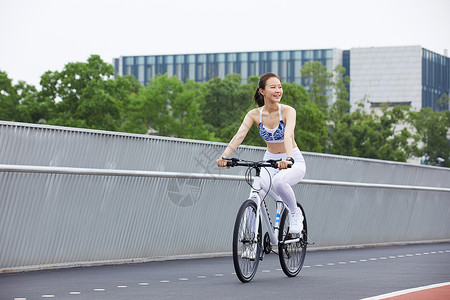 美女在户外公园里骑行背景图片