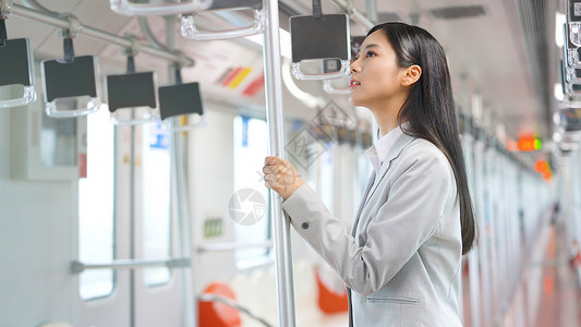 乘坐地铁手握扶手的女白领高清图片