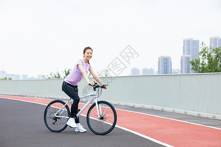 青年女性户外公园里骑行高清图片