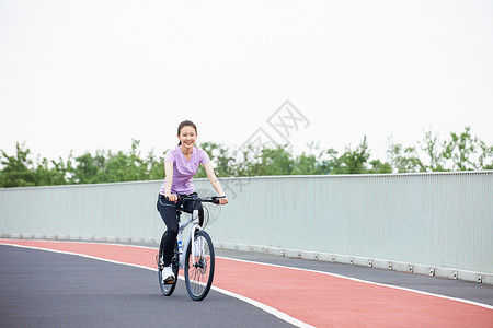 青年女性户外公园里骑行背景图片