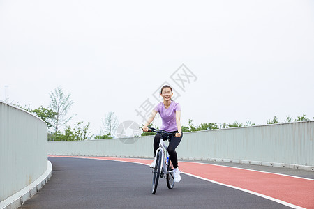 青年女性户外公园里骑行背景图片