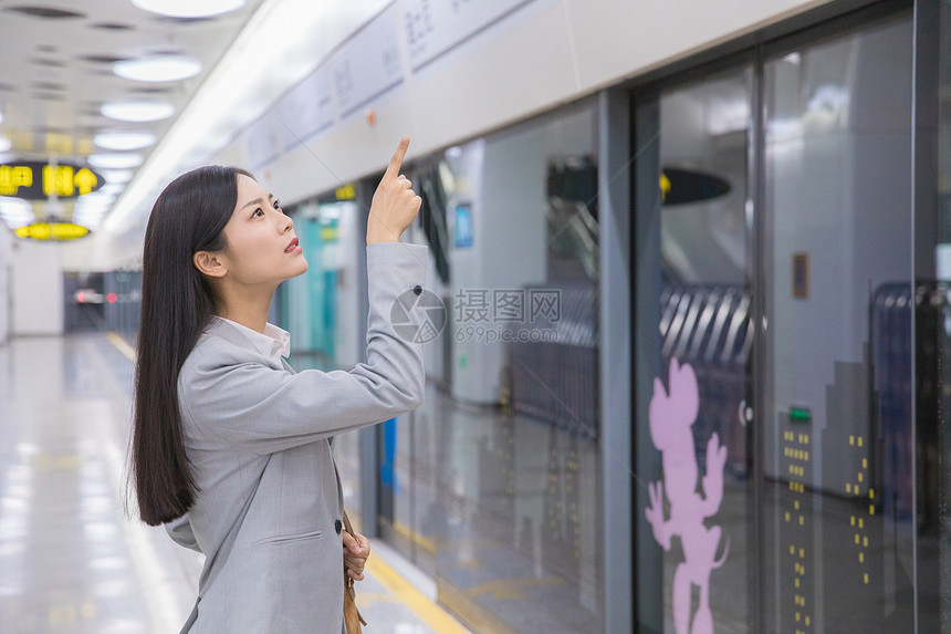 看地铁指示牌的商务女性图片