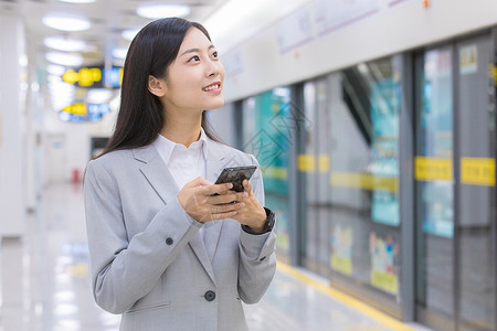 商务女性在地铁站玩手机图片