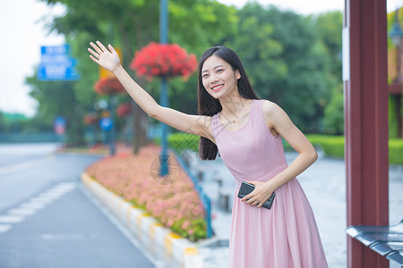 乘公交公交站台打车的年轻女性背景