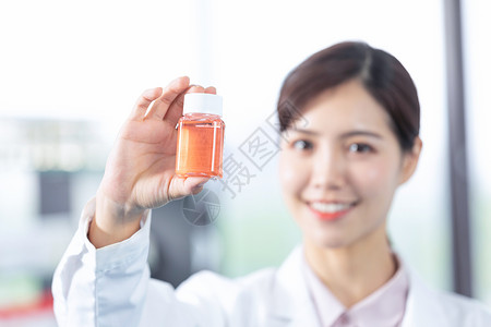 年轻女医生手拿药瓶展示图片