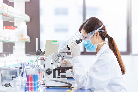 医疗研究使用显微镜年轻女医疗科研人员使用显微镜背景