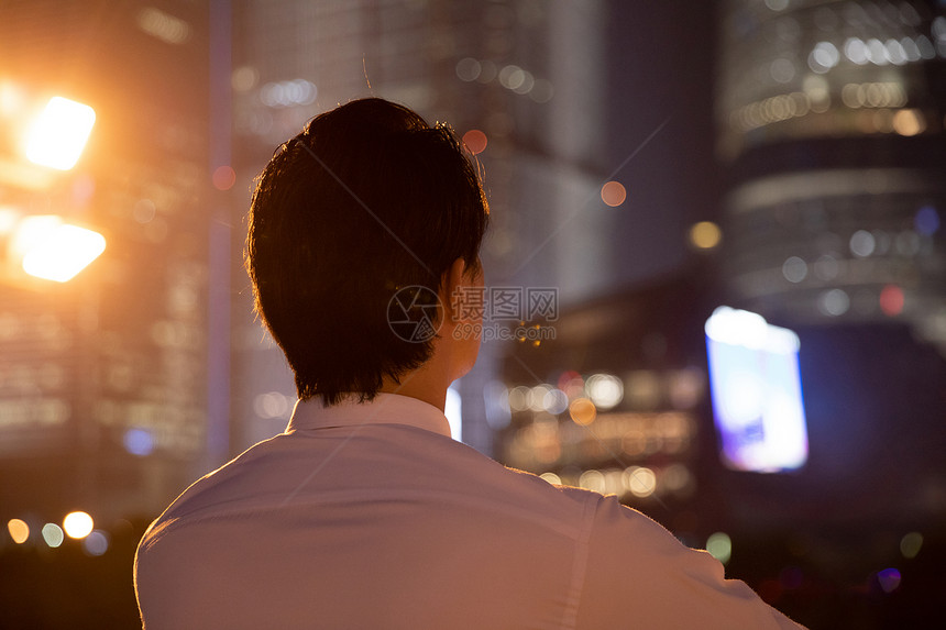 夜晚天桥上的都市商务男性背影图片