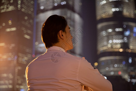 夜晚天桥上的都市商务男性背影图片