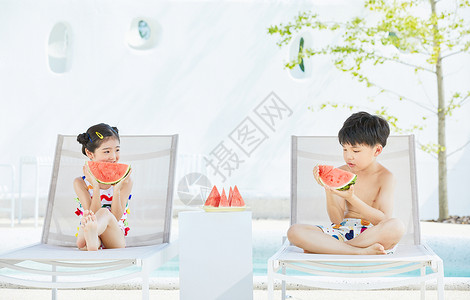 夏日小男孩和小女孩坐在躺椅上开心吃西瓜高清图片