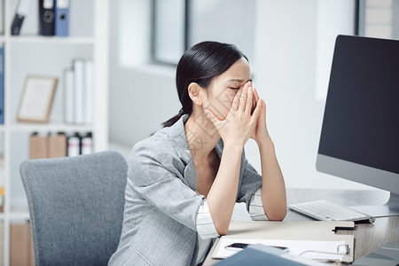 坐在办公桌前头痛的职场女性图片亚健康白领商务女性头痛背景