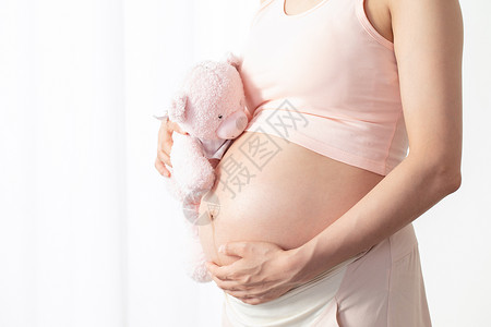 孕期健康孕妇抱着毛绒玩偶背景