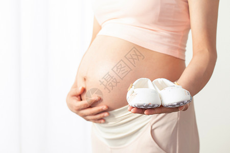 孕妇手拿宝宝鞋高清图片