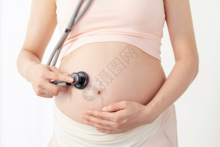 孕妇拿听诊器听肚子的胎动高清图片