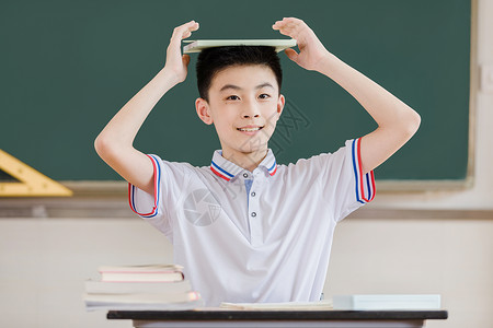 学生把书放在头顶上玩耍图片