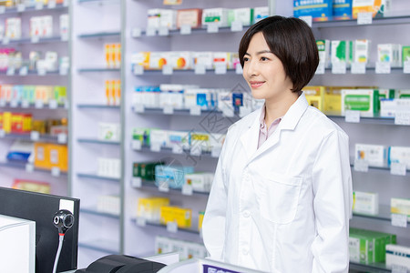药店站在收银台前面的药剂师背景图片
