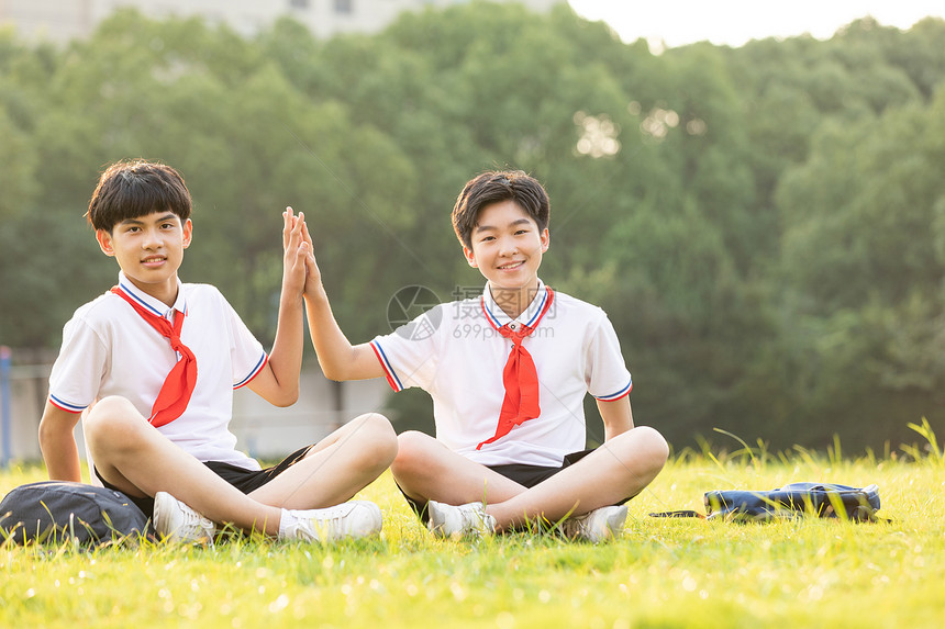 坐在操场草坪上击掌的同学图片