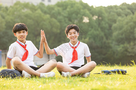 坐在操场草坪上击掌的同学图片