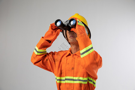 火灾应急使用望远镜指挥救援的消防员背景