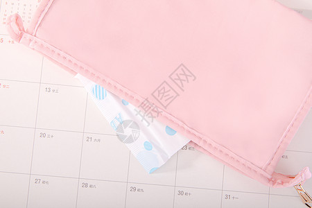 粉色日历化妆包露出的卫生巾背景