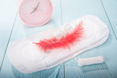粉红色羽毛桌面上的卫生巾卫生棉背景