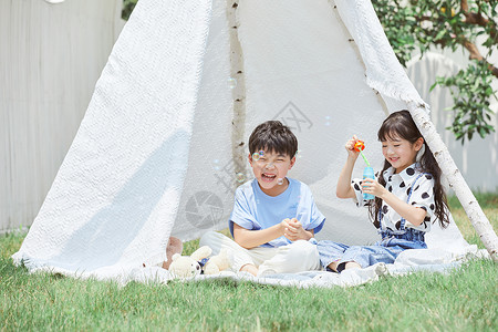 气泡帐篷小男孩和小女孩在帐篷里吹泡泡背景