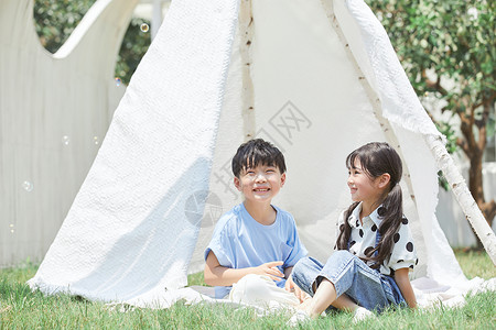 气泡帐篷小男孩和小女孩在帐篷里吹泡泡背景