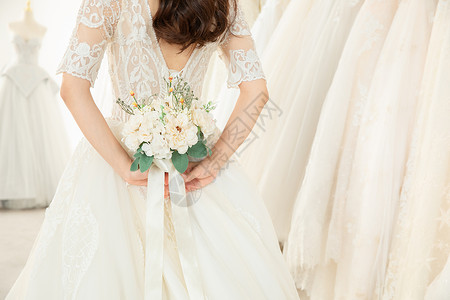 亚洲新娘拿手捧花的婚纱美女特写背景