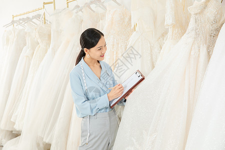 服装设计师记录婚纱尺码高清图片