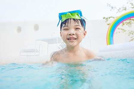 小男孩泳池里开心玩水图片