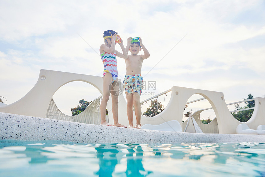 小男孩和小女孩站在泳池边图片