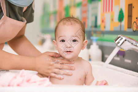 莒阿姨阿姨给婴幼儿洗澡特写背景