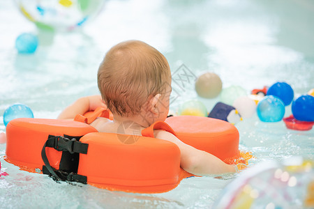 戴游泳圈游泳的婴幼儿背景图片