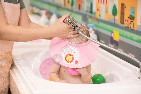 婴儿洗头阿姨给婴幼儿洗澡洗头特写背景